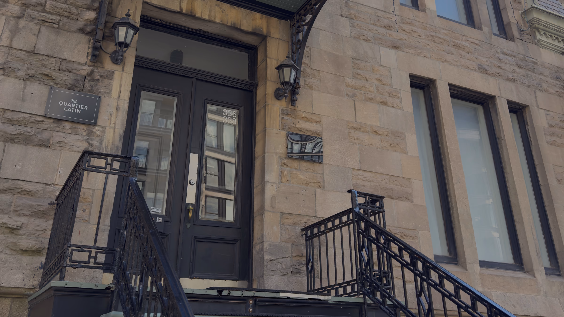 Entrée du 336 rue Sherbrooke Est : marquise noire, portes noires, pierre calcaire